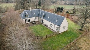 A large, single-story house with a sloped roof, surrounded by a well-maintained lawn and trees. - Stunning private villa for 10 guests with WIFI, TV, terrace and pets allowed (Corrimony)