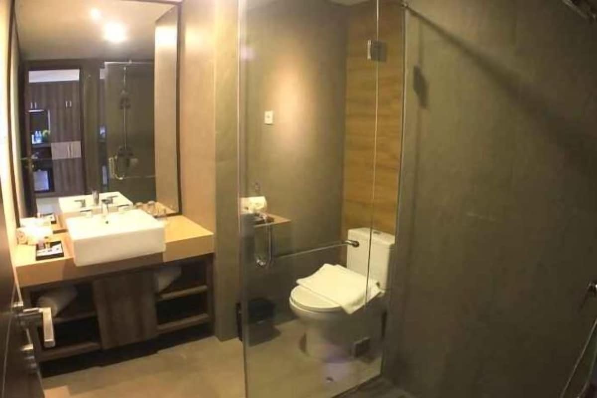 Un baño moderno con ducha de vidrio, lavamanos y retrete.