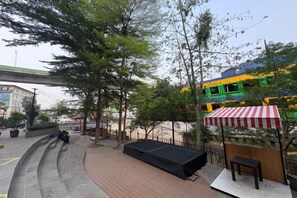 A park area with a curved pathway, benches, and a stage.