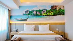 A hotel room with a bed, a nightstand, a lamp, and a painting of a beach scene. - Kebayoran Park Hotel (South Jakarta)