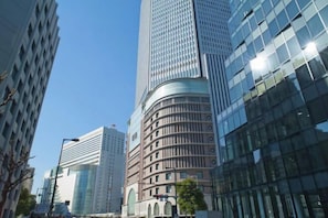 A modern high-rise building with a curved facade, surrounded by other tall buildings.
