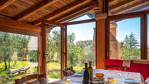 Una zona de dinar amb una taula ben posada per a dues persones, grans finestres i vista cap a l'exterior.