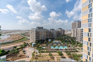 A modern hotel complex with multiple high-rise buildings, a swimming pool, and landscaped gardens. - Modern 1BR Dania 1 Apartment with Private Balcony (Dubai)