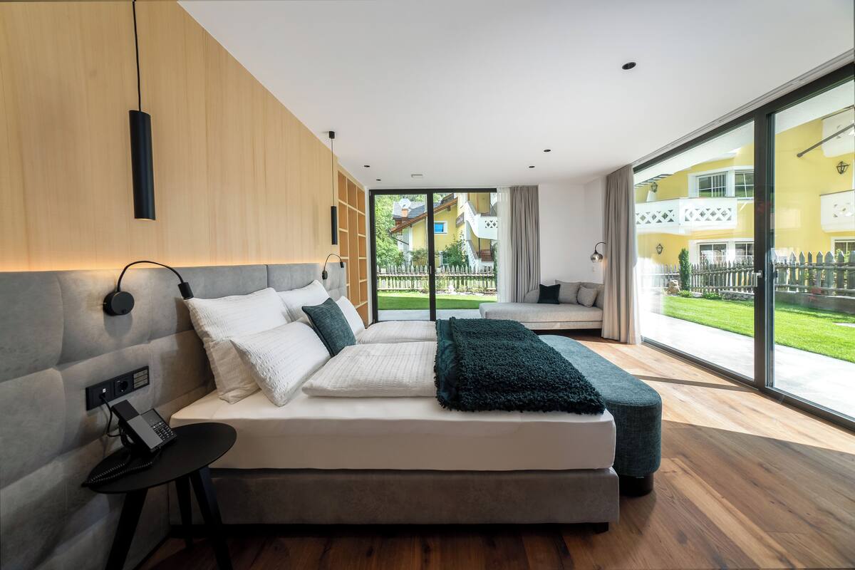 Un dormitorio moderno con una cama grande, un escritorio y vistas a un patio.