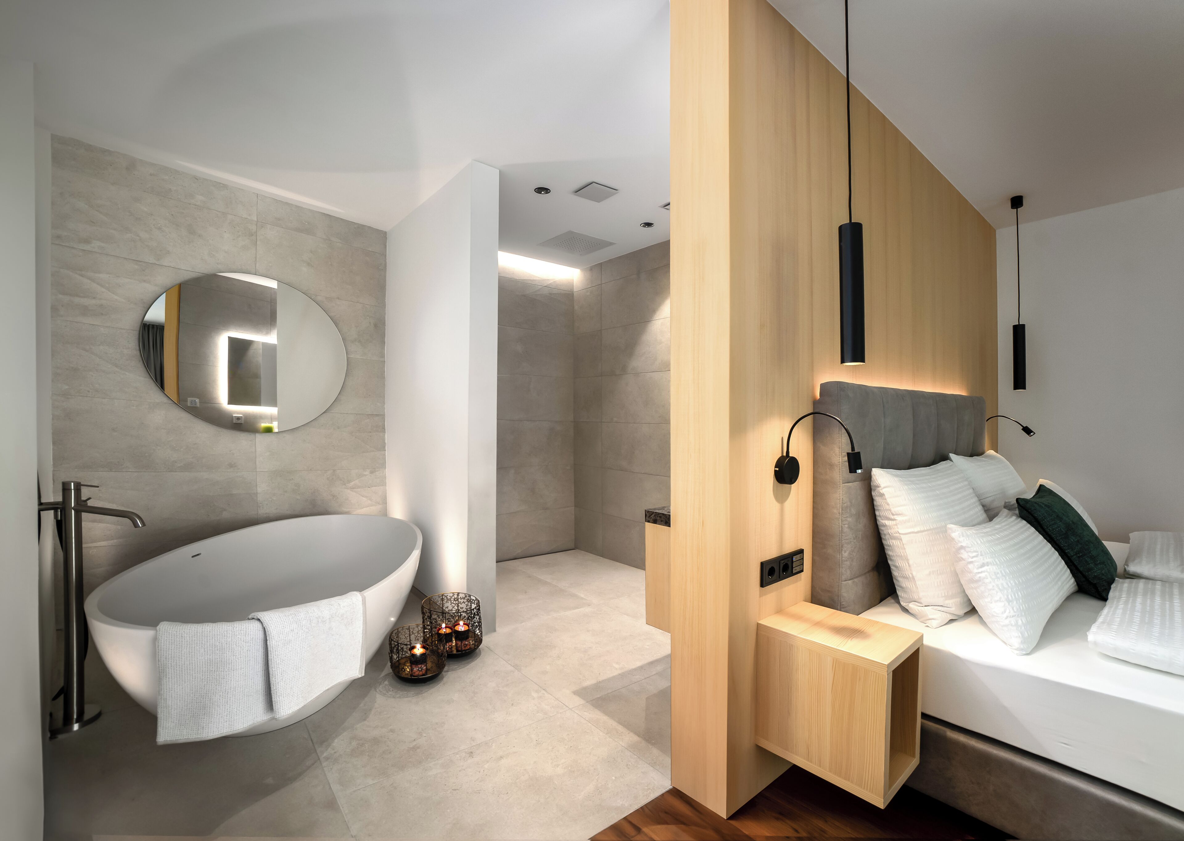 Une salle de bain moderne avec une baignoire sur pieds, un miroir rond et un espace douche.