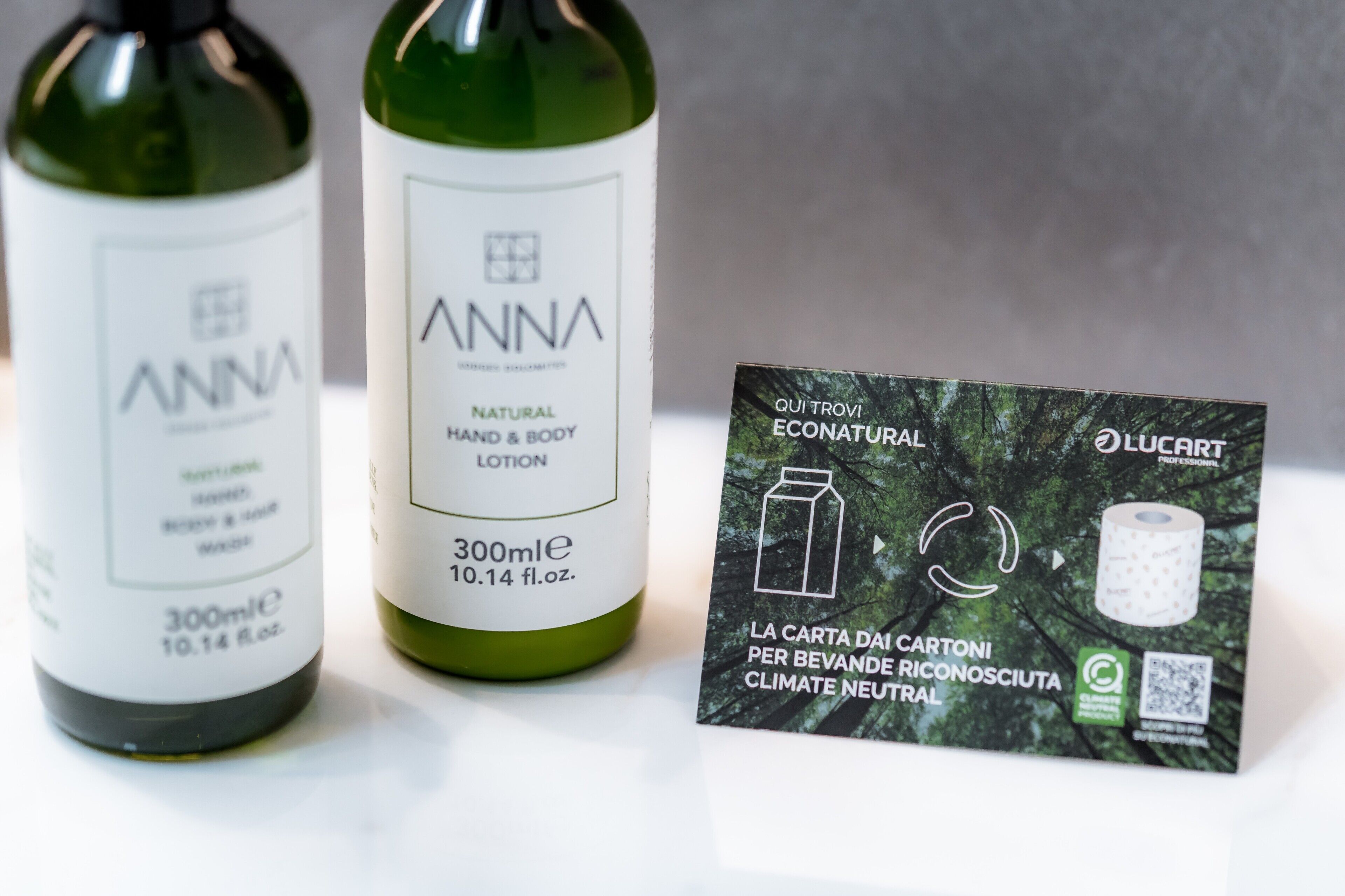 Dos botellas de loción corporal y para manos Anna natural y un paquete de papel higiénico ecológico Luccart.