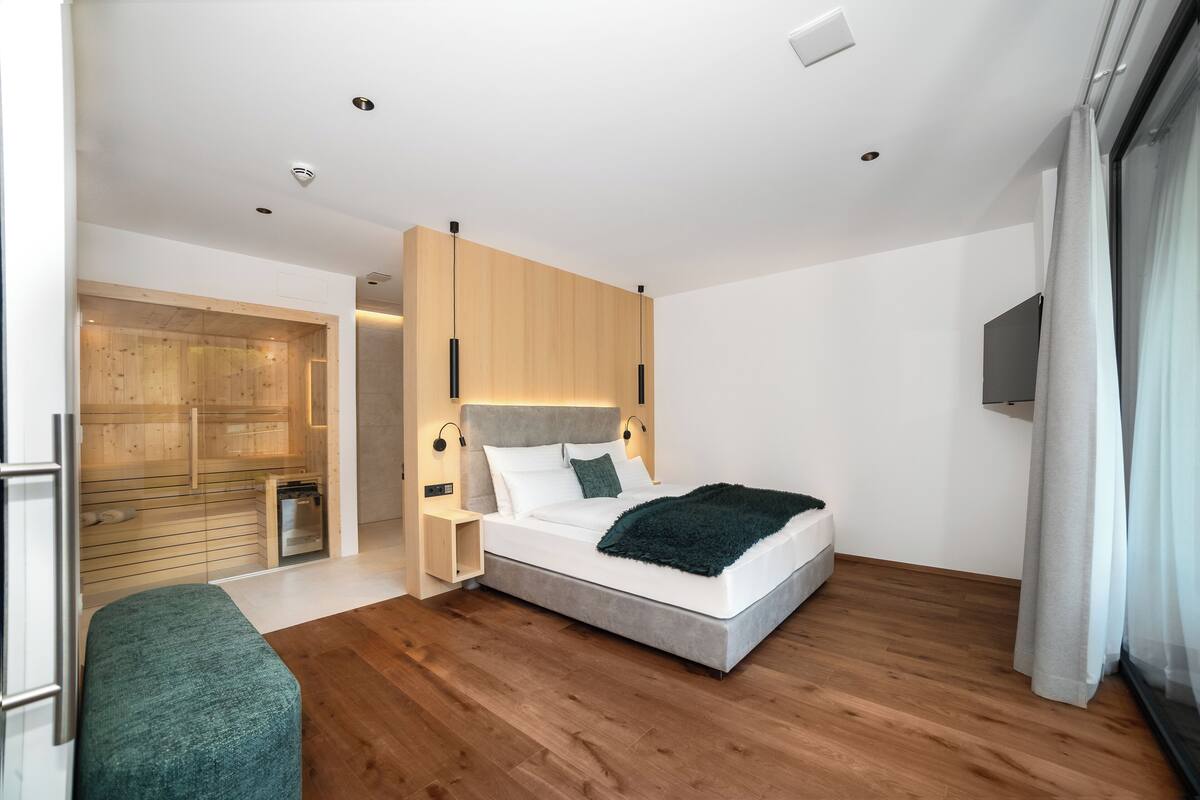 Un dormitorio moderno con cama, mesitas de noche, armario empotrado y zona de ducha.