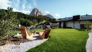 Ein modernes Haus mit gepflegtem Rasen und zwei Holzstühlen.