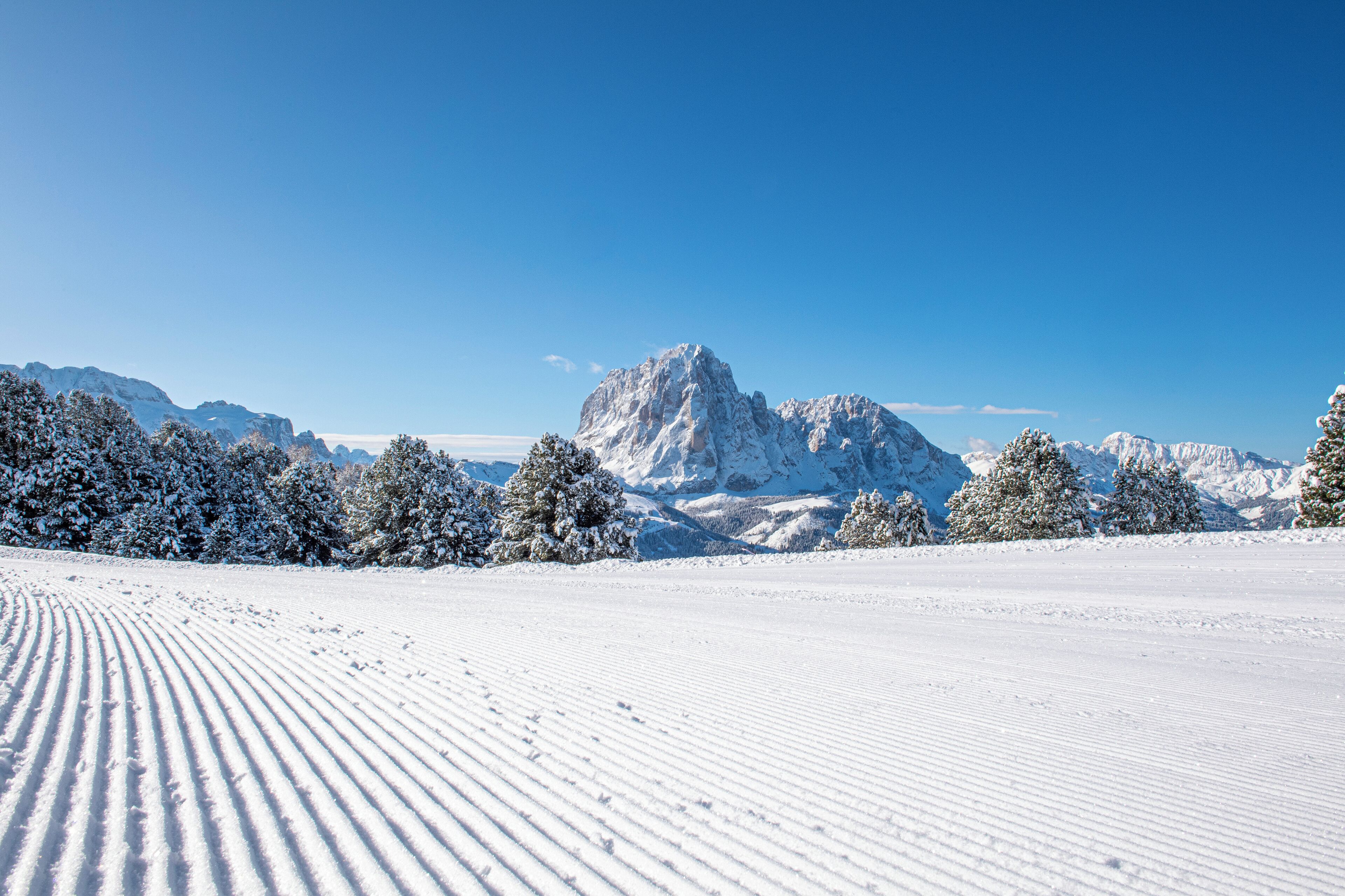Paesaggio montano innevato con cielo sereno.