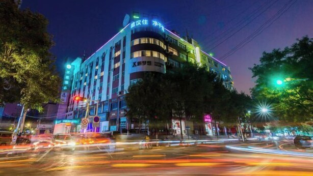 A multi-story hotel with illuminated signage, located at a busy intersection with visible traffic. - HanTing Hotel (Zhengzhou Railway Station Dehua Street) (Zhengzhou)
