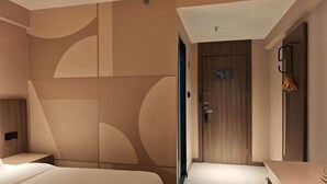 A modern hotel room with a large bed, a small bedside table, a wardrobe, and a bathroom with a shower area. - HanTing Hotel (Zhengzhou Railway Station Dehua Street) (Zhengzhou)