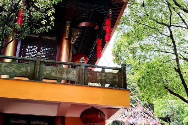 A traditional building with a red and gold facade, ornate wooden doors, and a balcony with a metal railing. - Xiangshan Huaxiang Villa (Xiangshan)