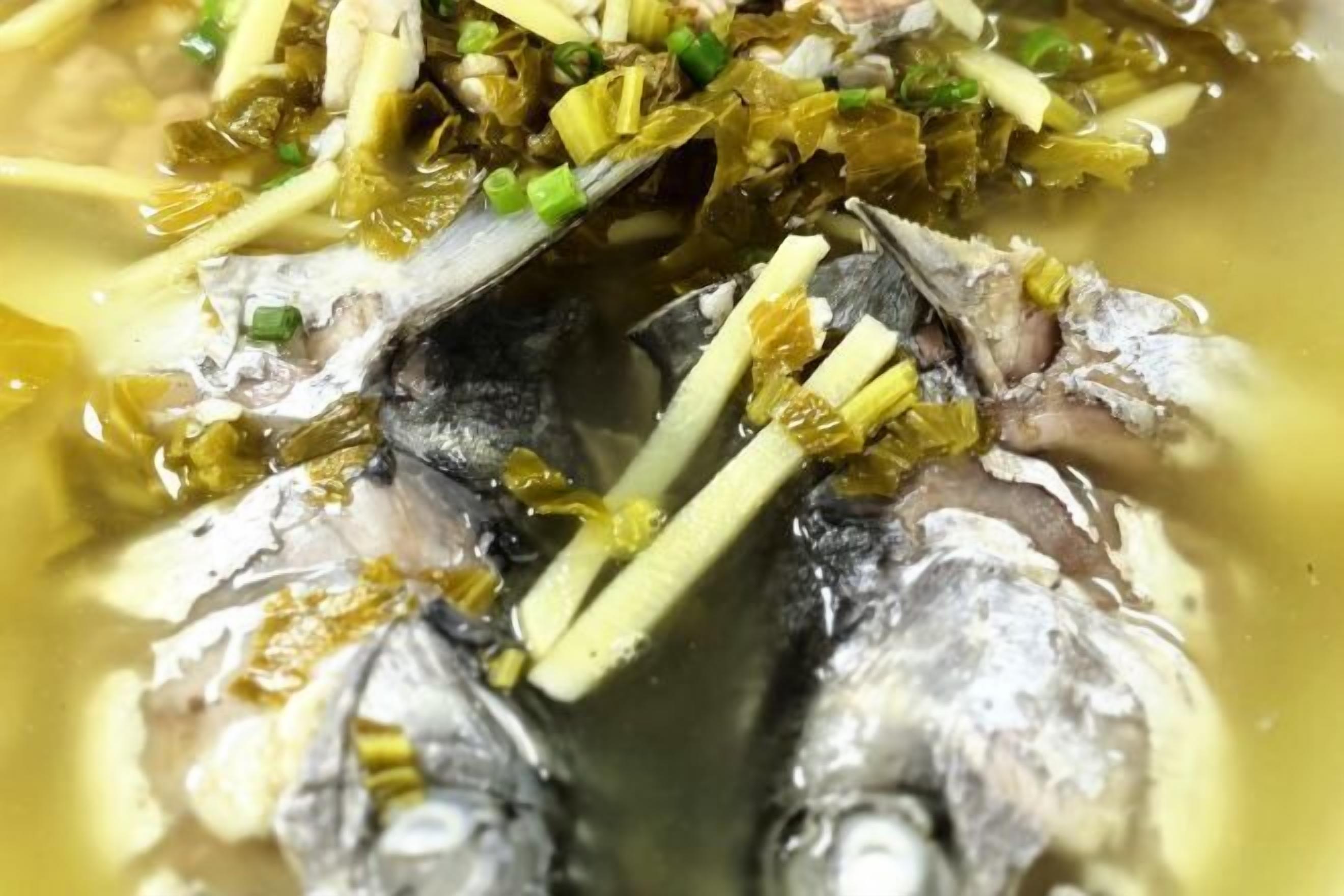 Primer plano de un plato de pescado con cebollas verdes y algas.