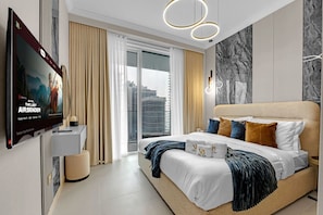 Ein modernes Schlafzimmer mit einem großen Bett, einem an der Wand montierten Fernseher und Blick auf die Stadt durch das Fenster.