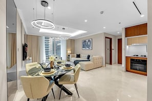 Ein modernes Wohnzimmer mit Essbereich, einer Couch, einer Küche und einem großen Fenster.
