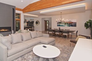 Una sala de estar moderna con un sofá modular, una mesa de centro redonda y una chimenea.