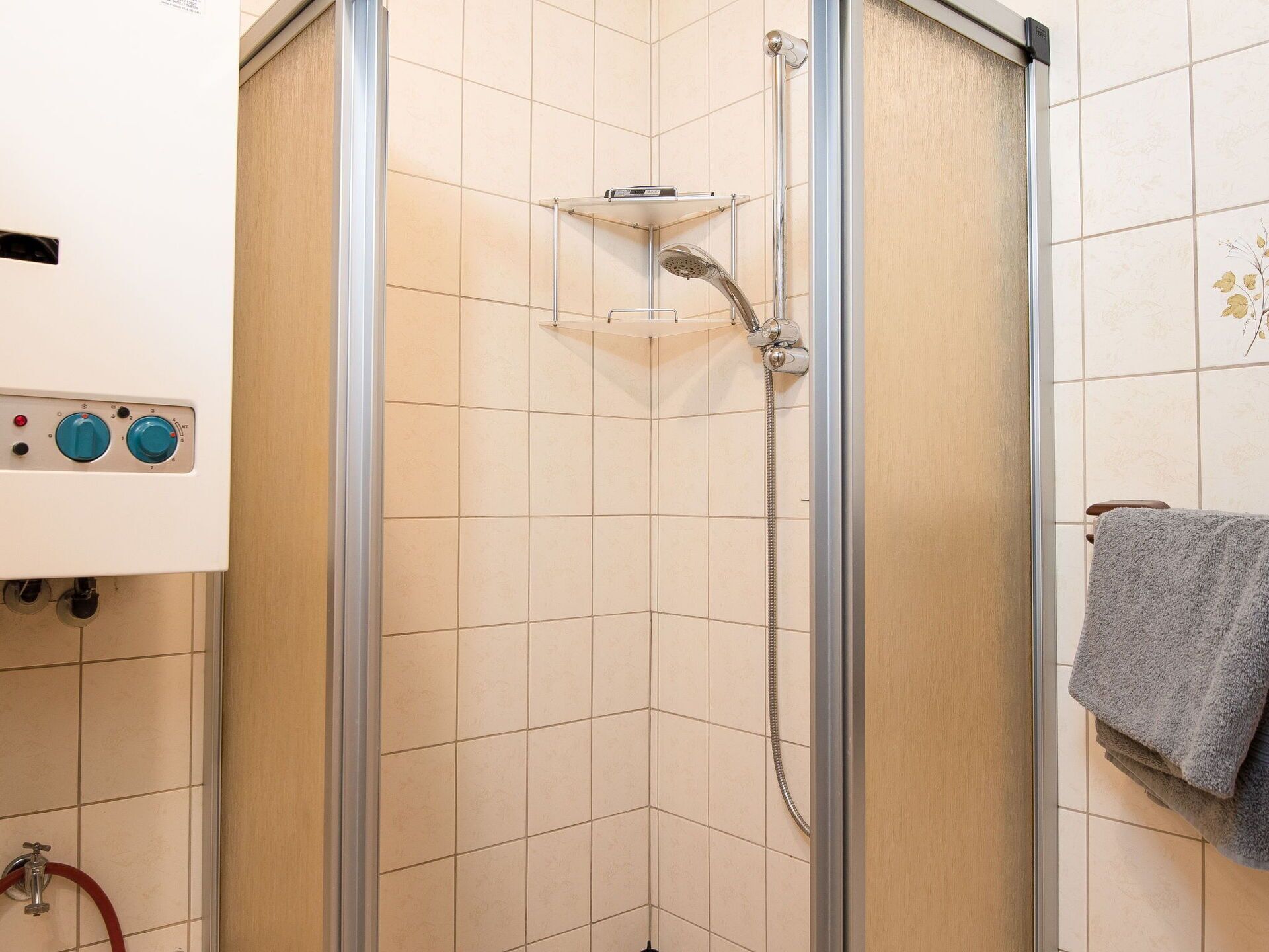 Eine Dusche mit Handbrause und fest installierter Bedienung.
