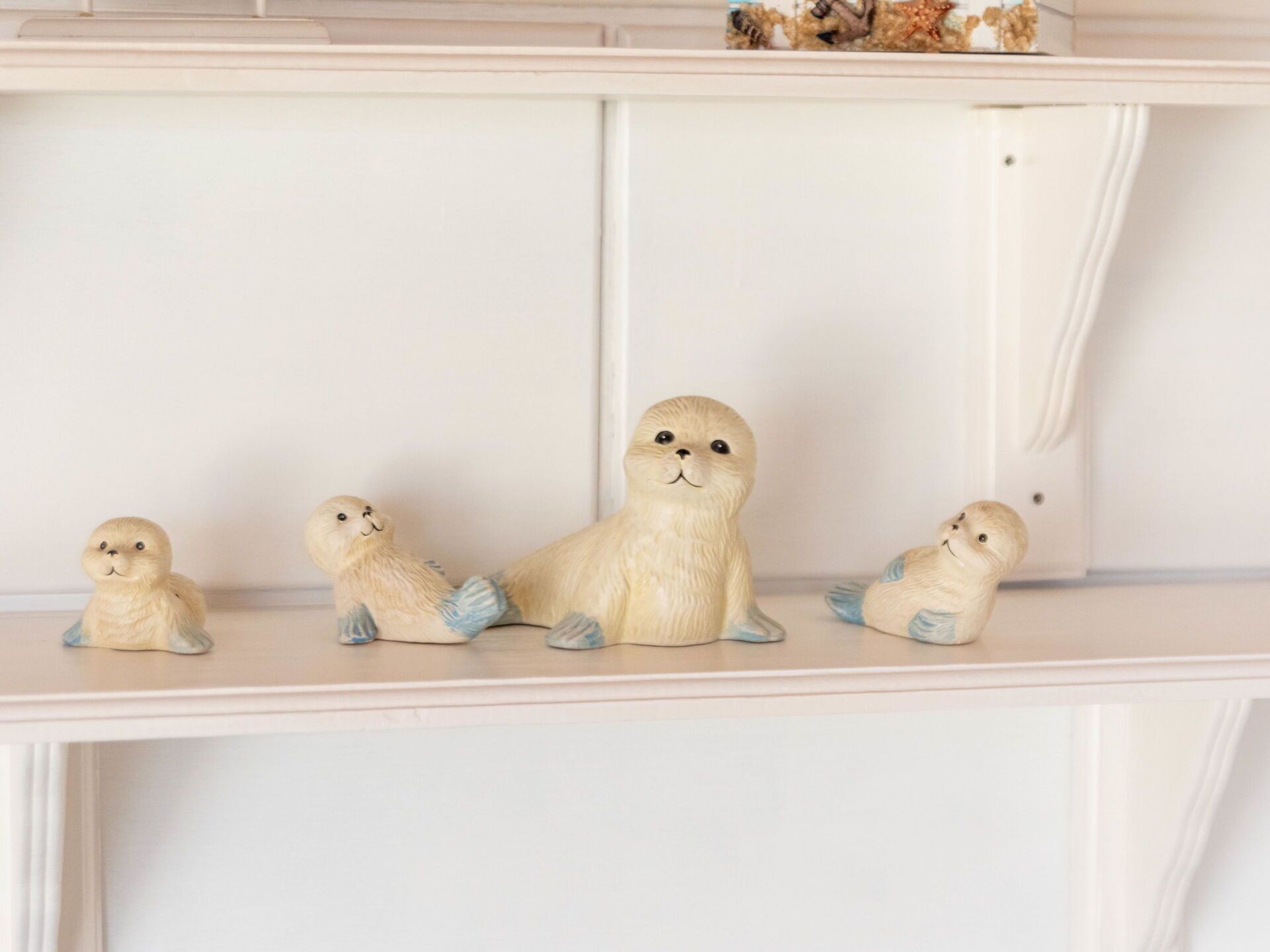 A shelf with five wooden figurines of seals.