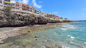 A coastal hotel with multiple balconies overlooking the sea, situated on a rocky cliff. - Cosy apartment for 6 people with WIFI, A/C, TV and patio (Telde)