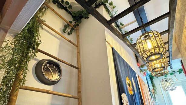 Een kamer met een houten ladder, een klok en een bordje met de tekst 'TISSUE'.