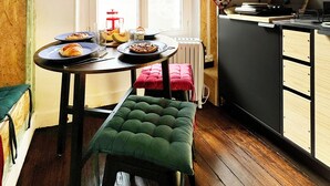 Een keuken met een eettafel, een bank en diverse keukenartikelen.