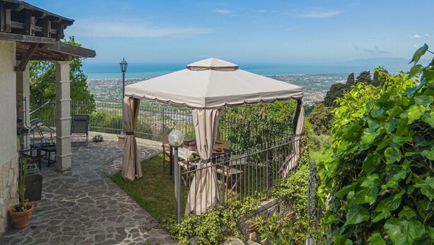 Un belvédère offrant une vue sur la mer, un chemin en pierre et un espace de détente extérieur.