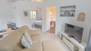 Una sala de estar moderna con un sofá, televisor y obras de arte en la pared.