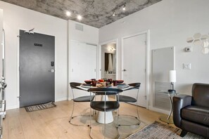 Un comedor moderno con una mesa redonda, cuatro sillas y un sofá de cuero negro.