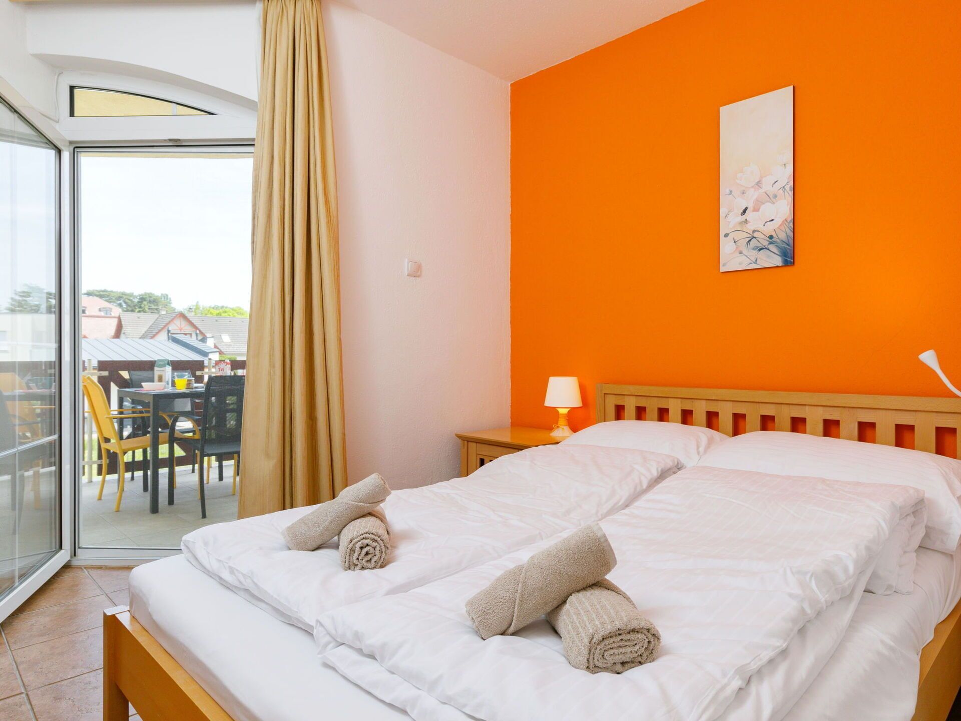 Une chambre d’hôtel avec un lit, une table de chevet, une lampe et une vue sur l’extérieur.