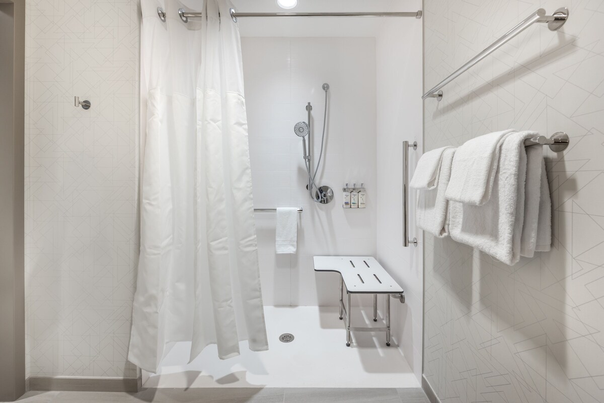 Un baño moderno con ducha, inodoro y toallero.