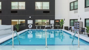 Une piscine avec un bâtiment moderne en arrière-plan.