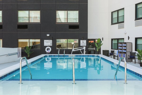 A swimming pool with a modern building in the background.