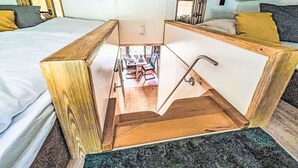 A compact room with a bed, a small table, and a shower area.