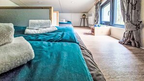 A bedroom with two beds, a window with curtains, a small table, and a potted plant. - Nice apartment in villa for 5 people with A/C, TV and terrace (Fischbachau)