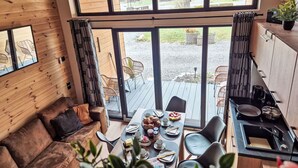A cozy cabin with a wooden interior, a dining area with a table set for two, and a kitchen with a stove. - Nice apartment in villa for 5 people with A/C, TV and terrace (Fischbachau)