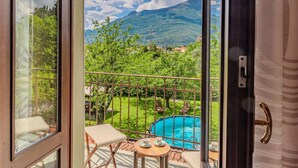 A balcony with a pool, a table with cups, and a view of mountains. - Stunning private villa for 8 people with private pool, WIFI, TV, terrace and panoramic view (Dervio)