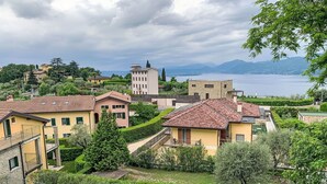A residential area with houses, a swimming pool, and a view of a lake and mountains. - Nice apartment for 8 people with pool and terrace (Torri Del Benaco)