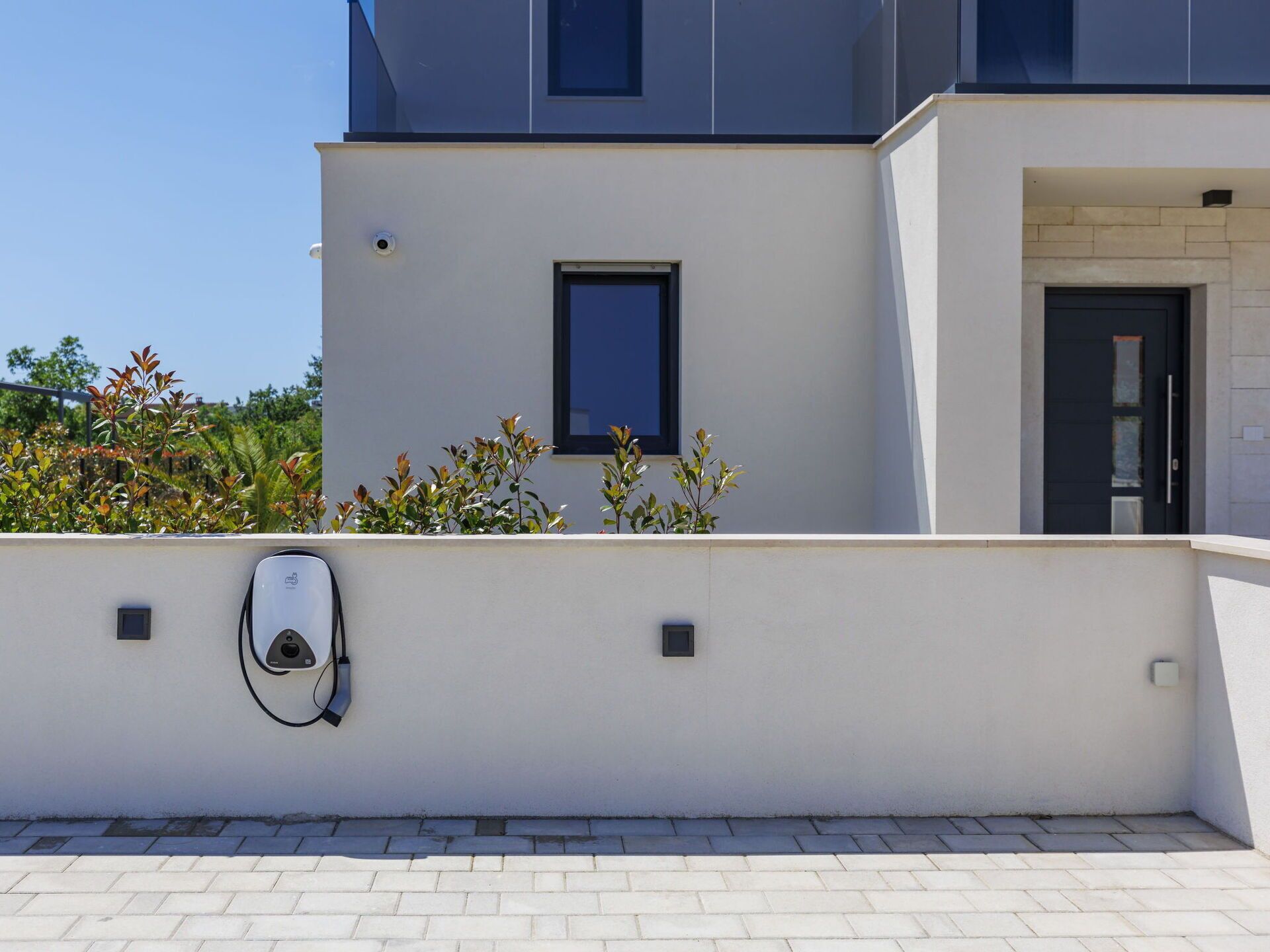 A modern building with a clean, white facade, a small window, and a door.