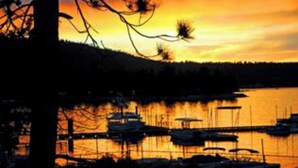 Um pôr do sol sobre a água, com barcos atracados.