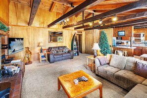 A cozy living room with a fireplace, a sofa, a coffee table, and a television.
