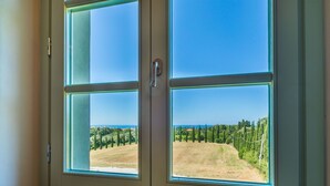 A window with a view of a grassy field and trees. - Beautiful apartment for 4 people with pool, A/C, WIFI, TV, patio, pets allowed and panoramic view (Rosignano Marittimo)
