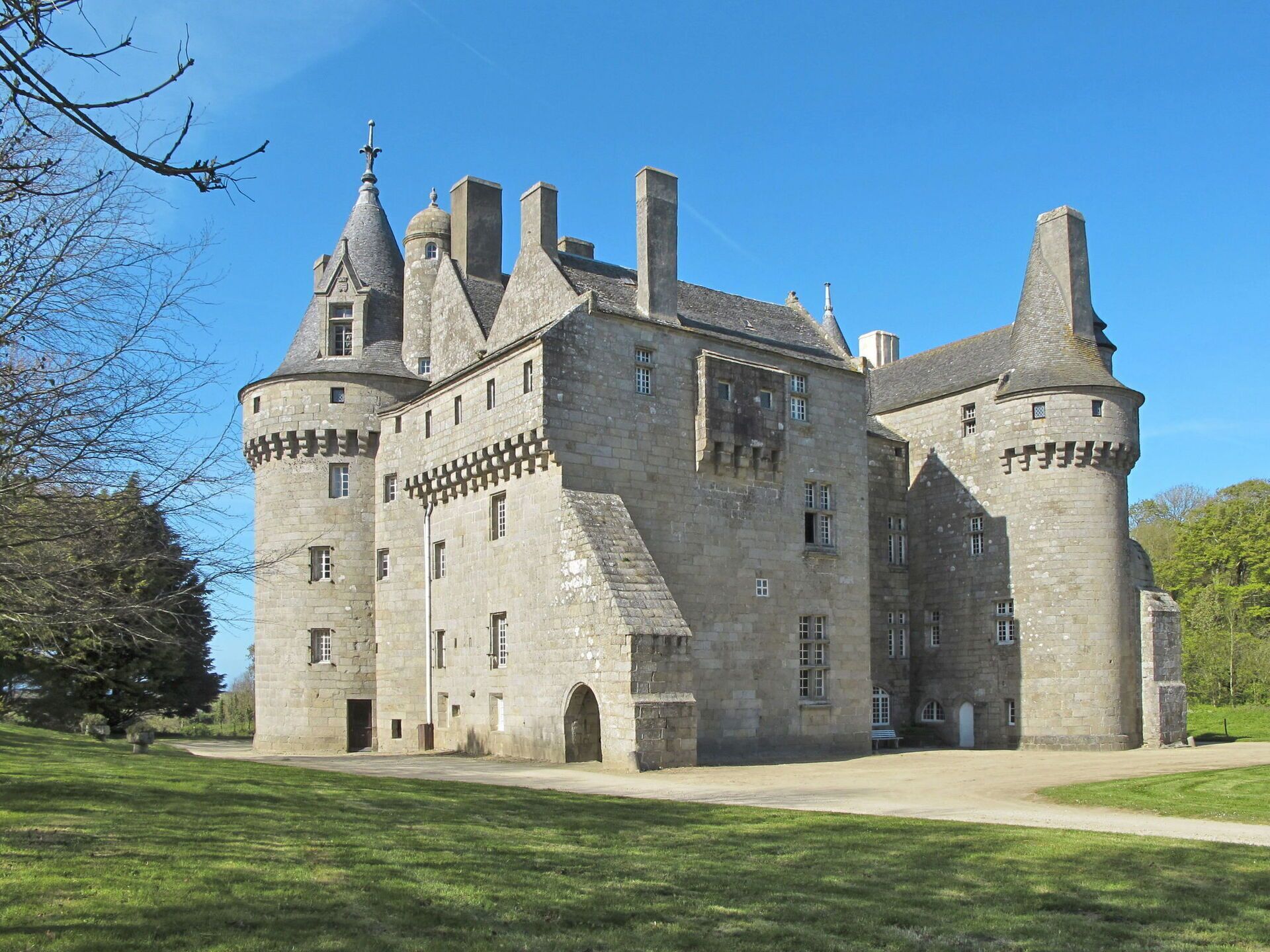 A large, historic stone castle with multiple towers and arched windows.