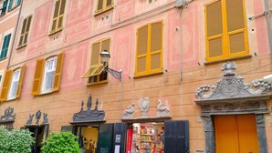 A building with a pink facade, yellow shutters, and a bookstore entrance. - Lovely apartment for 6 people with WIFI and TV (Sestri Levante)
