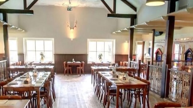 A spacious dining hall with wooden tables and chairs, large windows, and a high ceiling with exposed beams. - Private Sanctuary/Zen Den/nature lovers (Voorthuizen)
