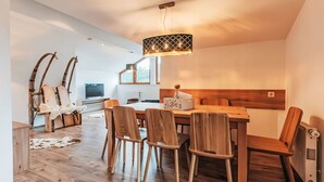 Una cucina moderna con mobili in legno, un tavolo da pranzo e una lampada a sospensione originale.