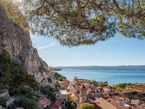 Un pueblo costero con edificios históricos, una imponente torre de iglesia y un acantilado rocoso con vistas al mar.