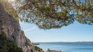 Eine Küstenstadt mit historischen Gebäuden, einem markanten Kirchturm und einer felsigen Klippe mit Blick aufs Meer.