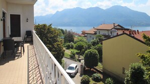 A balcony with a table and chairs, overlooking a lake and mountains. - Stunning private villa for 11 guests with WIFI, TV, balcony and pets allowed (Arizzano)