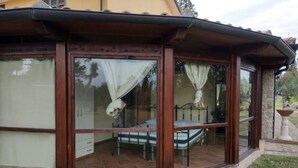 Une pièce avec un lit, une petite table et une fenêtre avec des rideaux.