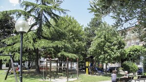 Ein Park mit Spielgeräten, Bänken und einer Laterne.